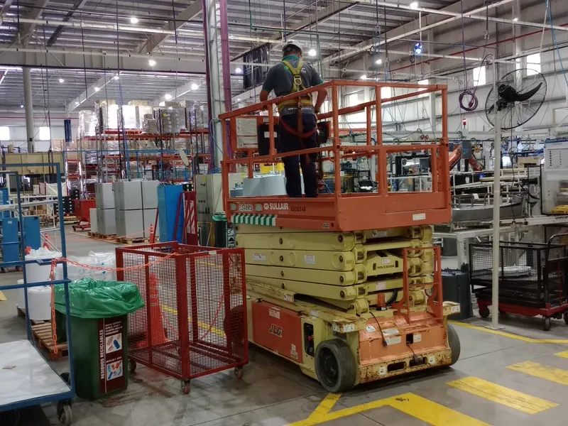 Obra eléctrica en altura con plataforma elevadora dentro de un edificio